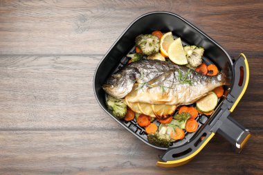 Ahşap masada fırında balık, limon ve sebze. Metin için boşluk