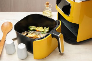 Pişmiş balık, limon ve sebzeler, tavada, beyaz ahşap masada, yakın plan.