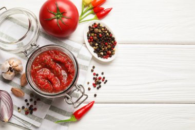 Kavanozda salsa sosu ve beyaz ahşap masada malzemeler. Metin için boşluk