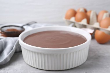 Gri masadaki kasede çiğ çikolata hamuru, yakın plan.