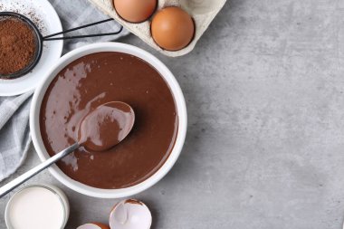 Çiğ çikolata hamuru kasede ve malzemeler gri masada, düz yerde. Metin için boşluk