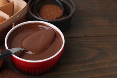 Kase içinde çiğ çikolata hamuru ve ahşap masadaki malzemeler, yakın plan. Metin için boşluk