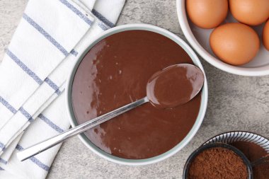 Çiğ çikolata hamuru kasede ve malzemeler gri masada, düz yerde.