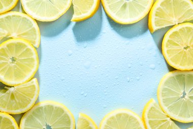 Açık mavi arkaplanda limon ve su damlaları var. Metin için boşluk