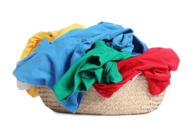 Hasır çamaşır sepeti beyaza izole edilmiş renkli kıyafetlerle dolu.
