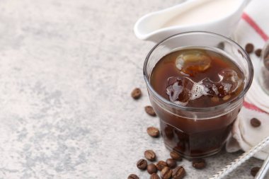 Tasty iced coffee and beans on light table, closeup. Space for text