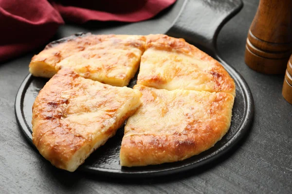 Lezzetli Megrelian Khachapuri 'yi siyah masaya koyun, yakın plan.
