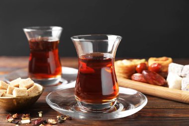 Geleneksel Türk çayı, bira, şeker ve tatlıları ahşap masada, yakın plan
