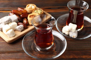 Geleneksel Türk çayı, ahşap masada şekerlerle servis edilir.