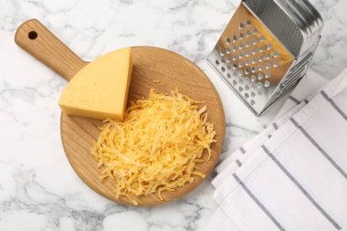 Beyaz mermer masada rendelenmiş ve rendelenmiş peynir.