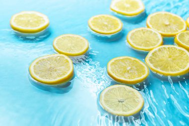 Açık mavi arkaplanda limon dilimleri, yakın plan.