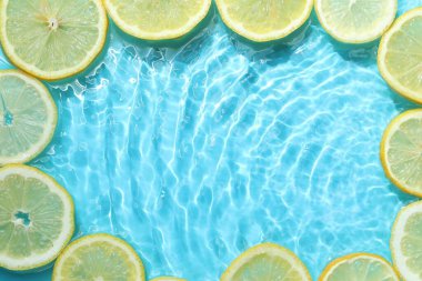 Açık mavi arka planda limon dilimleri, düz. Metin için boşluk