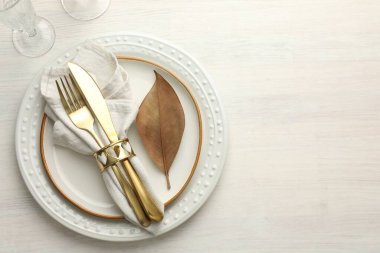 Beautiful table setting with autumn decor on white wooden background, top view. Space for text