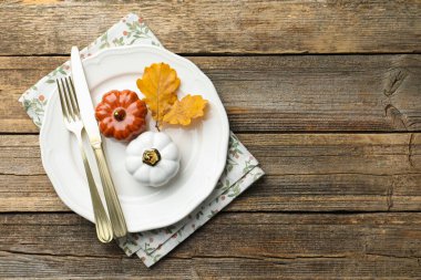 Beautiful table setting with autumn decor on wooden background, top view. Space for text