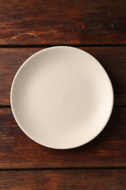 Ahşap masada boş seramik tabak, üst manzara.