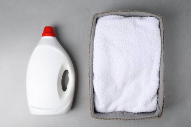 Gri masaya bir şişe yumuşatıcı ve havlu, düz yatıyordu.