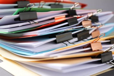 Many folders with documents and binder clips on grey background, closeup
