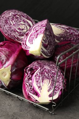 Whole and cut red cabbages on grey table, closeup