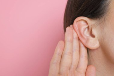 Pembe arka planda göğüs göğüse hareket gösteren bir kadın, yakın plan. Metin için boşluk