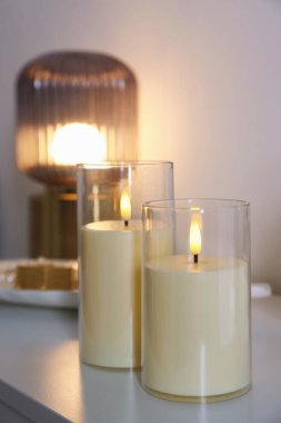 Dekoratif LED mumlar ve lambalar beyaz masa içinde, yakın plan.