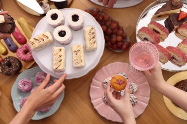 İnsanlar açık büfeden farklı tatlılar ve içecekler alıyor.