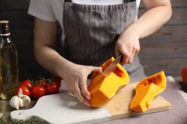 Masada taze balkabağı kesen kadın, yakın plan.