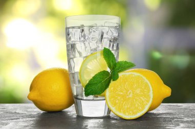 Limonlu su ve buzlu cam küpler masanın üzerinde, pencereye karşı.