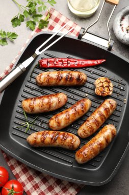 Izgara sosis ve baharatlı tava gri masada, düz yatıyordu.