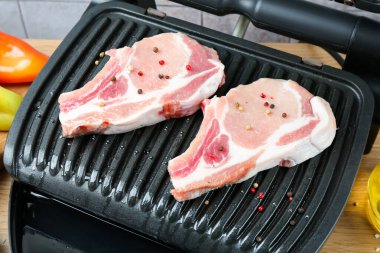 Tahta masada çiğ etle elektrikli ızgara, yakın plan.