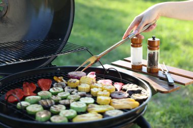 Vejetaryen barbeküsü. Dışarıdaki ızgarada sebze pişiren kadın, yakın plan.