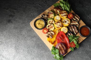 Vejetaryen barbeküsü. Gri masada servis edilen lezzetli ızgara sebzeler, üst manzara. Metin için boşluk