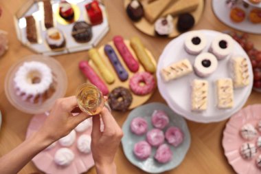 Misafir, açık büfeden bir bardak köpüklü şarap alıyor.