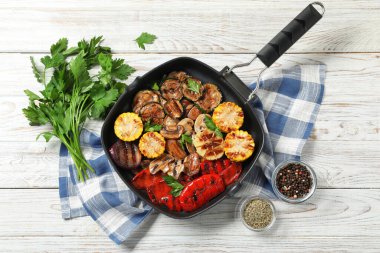 Tavada mantarlı nefis ızgara sebzeler ve hafif ahşap masada baharatlar.