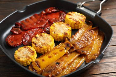 Ahşap masada tavada nefis ızgara sebzeler, yakın plan.