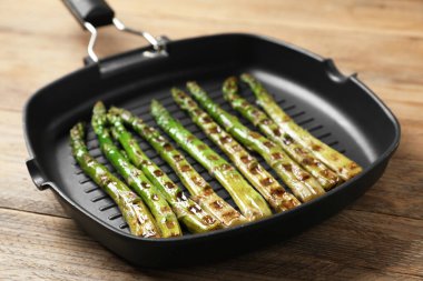 Ahşap masanın üstünde nefis ızgara kuşkonmaz, yakın plan.