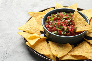 Gri masada nachos ile lezzetli salsa sosu, yakın plan.