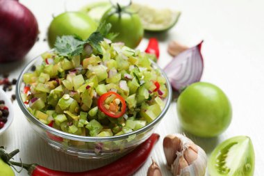 Lezzetli salsa sosu ve malzemeler beyaz ahşap masada, yakın plan.