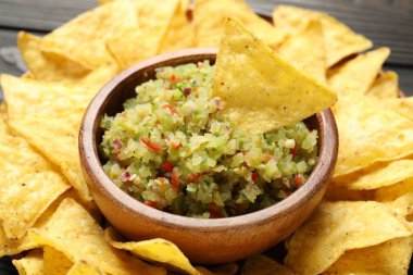 Tabakta salsa sosu ve masada nachos, yakın plan.