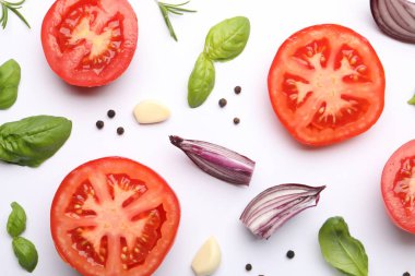 Beyaz arka planda olgun kırmızı domatesler, baharatlar ve otlar.