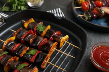 Siyah masada servis edilen lezzetli ızgara sebzeli şişler, yakın plan.