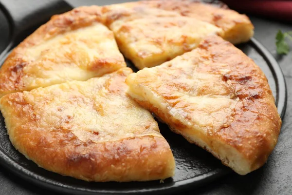Lezzetli Megrelian Khachapuri 'yi siyah masaya koyun, yakın plan.