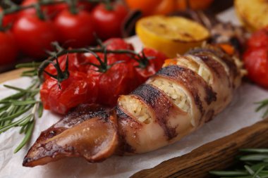 Lezzetli dolma kalamar, biberiye ve domatesler masada, yakın plan.