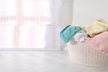 Çamaşır sepeti beyaz mermer kaplama yüzey üzerinde giysi dolu, metin için boşluk