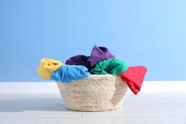 Çamaşır sepeti açık mavi duvarın yanında.