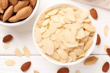 Taze badem gevrekleri ve beyaz ahşap masada fındıklar.