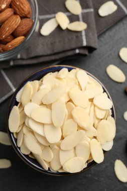 Taze badem gevrekleri kasede ve fındıklar gri masada, düz yatıyordu.