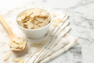 Beyaz mermer masada taze badem taneleri, yakın plan. Metin için boşluk