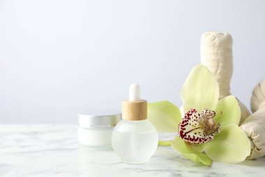 Beyaz mermer sehpanın üzerinde gerekli yağ ve bitkisel torbalar bulunan güzel bir spa kompozisyonu, yakın plan. Metin için boşluk