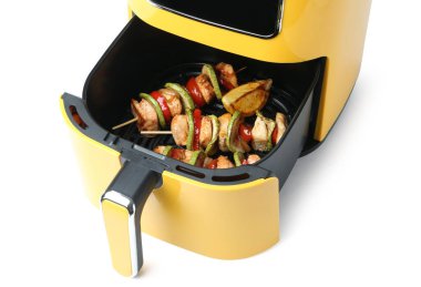 Kızarmış tavuklu şişler ve tavuklu sebzeler, beyaz tavada izole edilmiş.