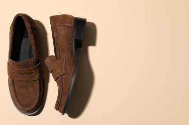 Pair of stylish brown shoes on beige background, flat lay. Space for text